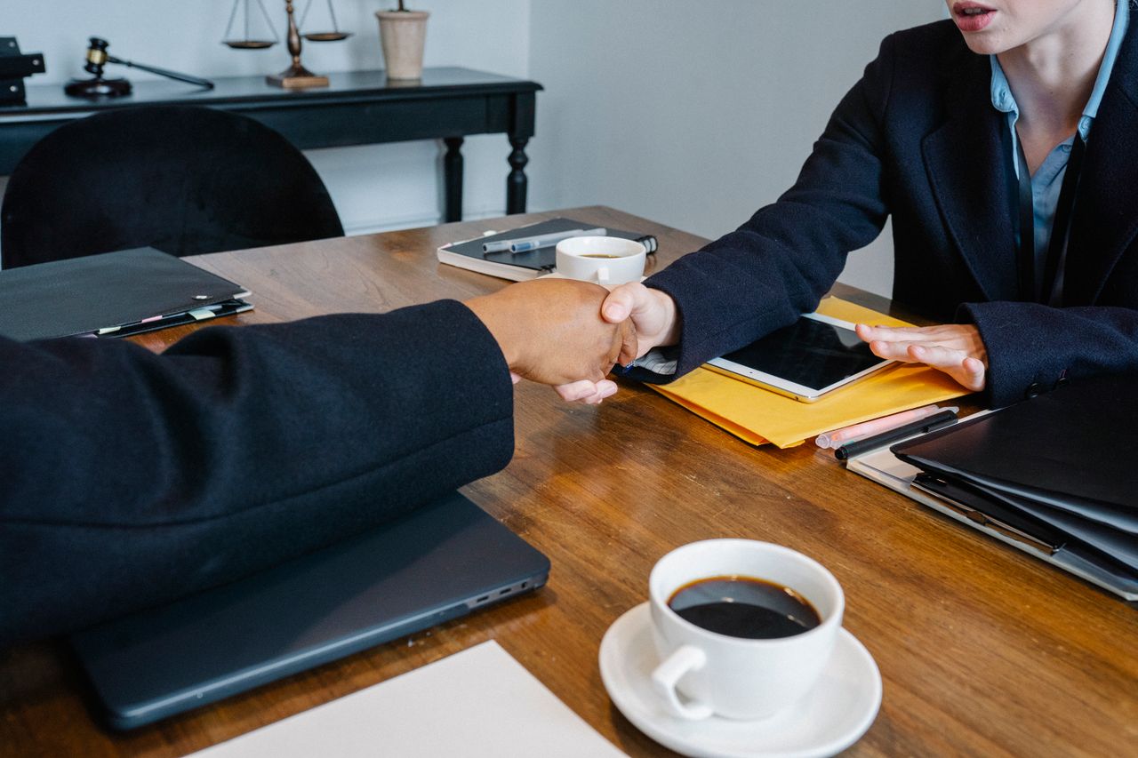 The Art of Drawing Readers In: Your attractive post title goes here Crop anonymous multiethnic coworkers in elegant outfit shaking hands at table with tablet and documents in office