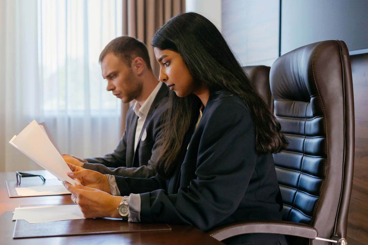 Crafting Captivating Headlines: Your awesome post title goes here Two professionals reviewing documents in an office setting, showcasing teamwork and diversity.